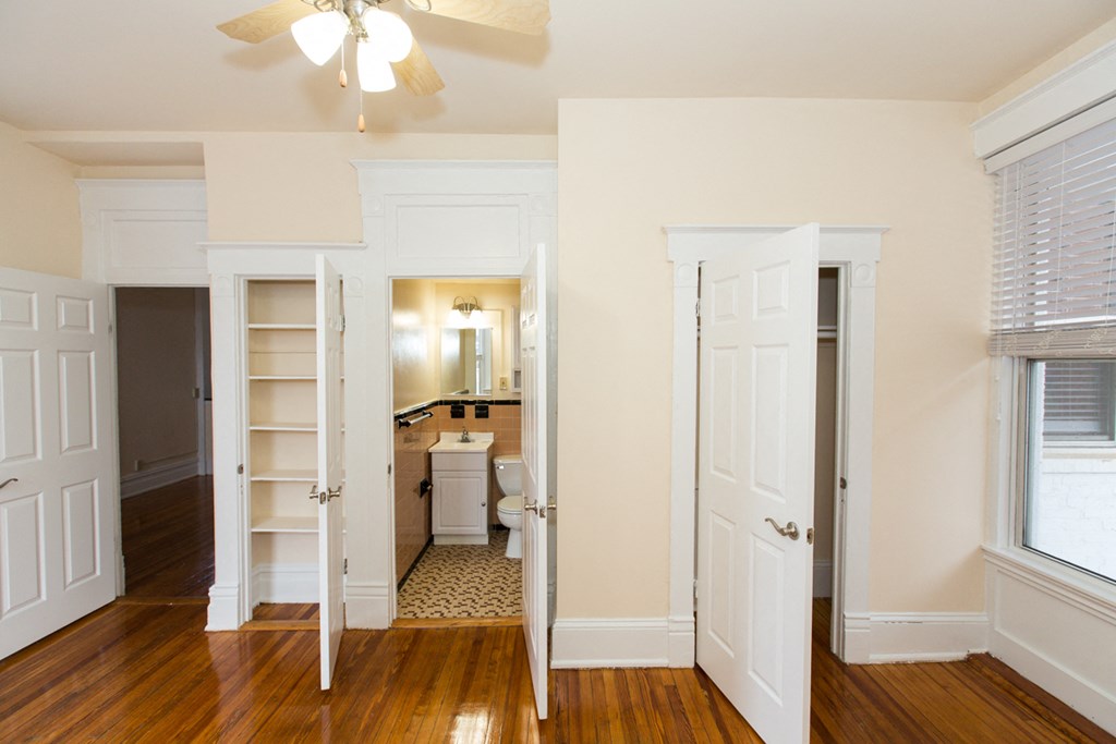 vacant bedroom with large windows, closet, ceiling fan and view of bathroom at dupont apartments in washington dc