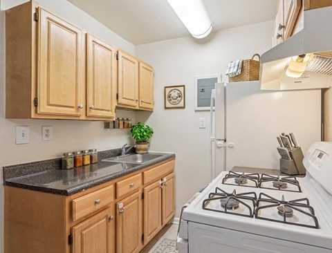 A kitchen with wooden cabinets and a white stove.