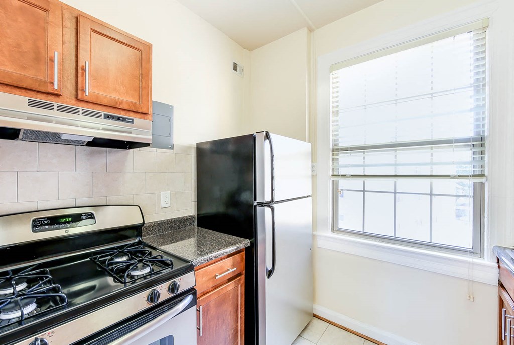 kitchen with stainless steel appliances, tile backsplash and window at the frontenac apartments in van ness washington dc