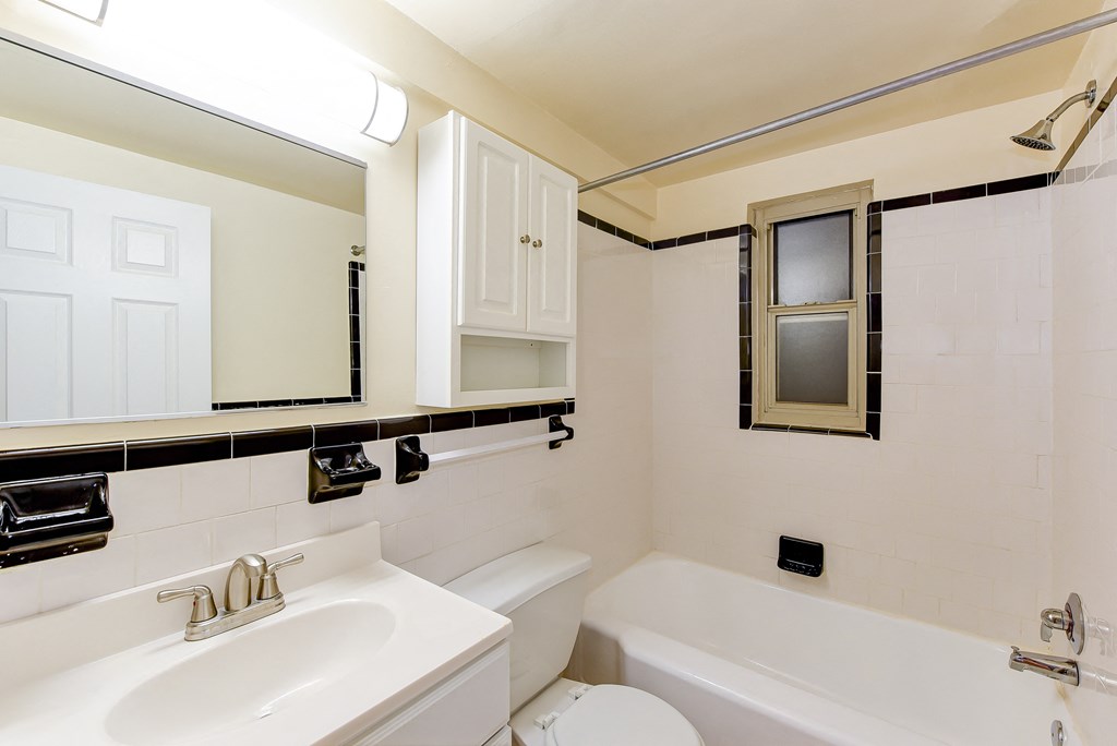 bathroom with tub, vanity, large mirror and tile details at sherry hall apartments in washington dc