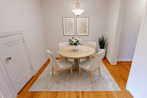 A white dining room with a round table and chairs.