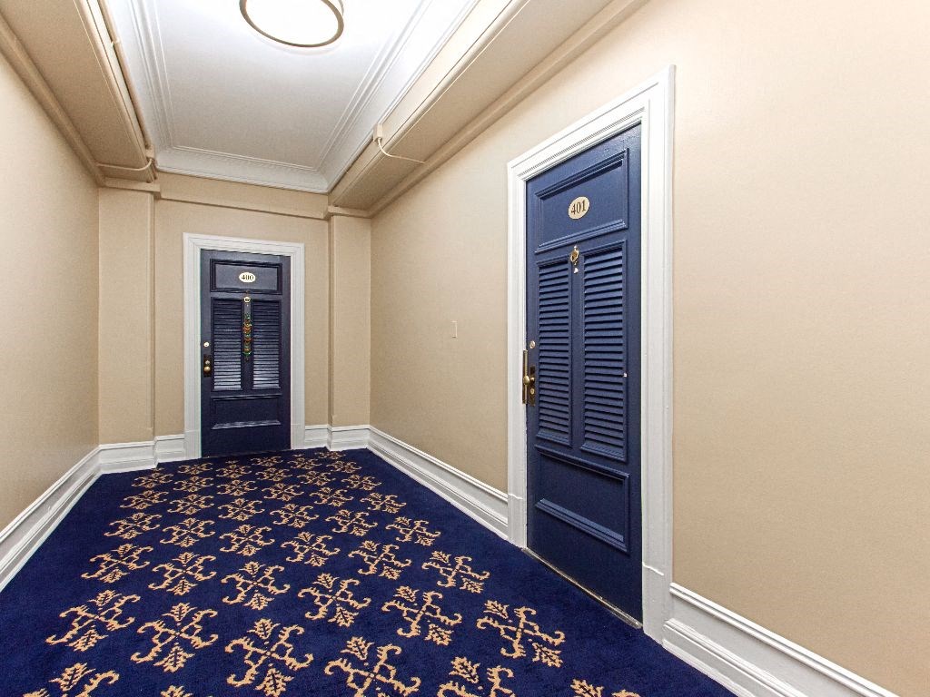 a corridor with two blue doors and a carpeted floor at the calverton apartments in washington dc