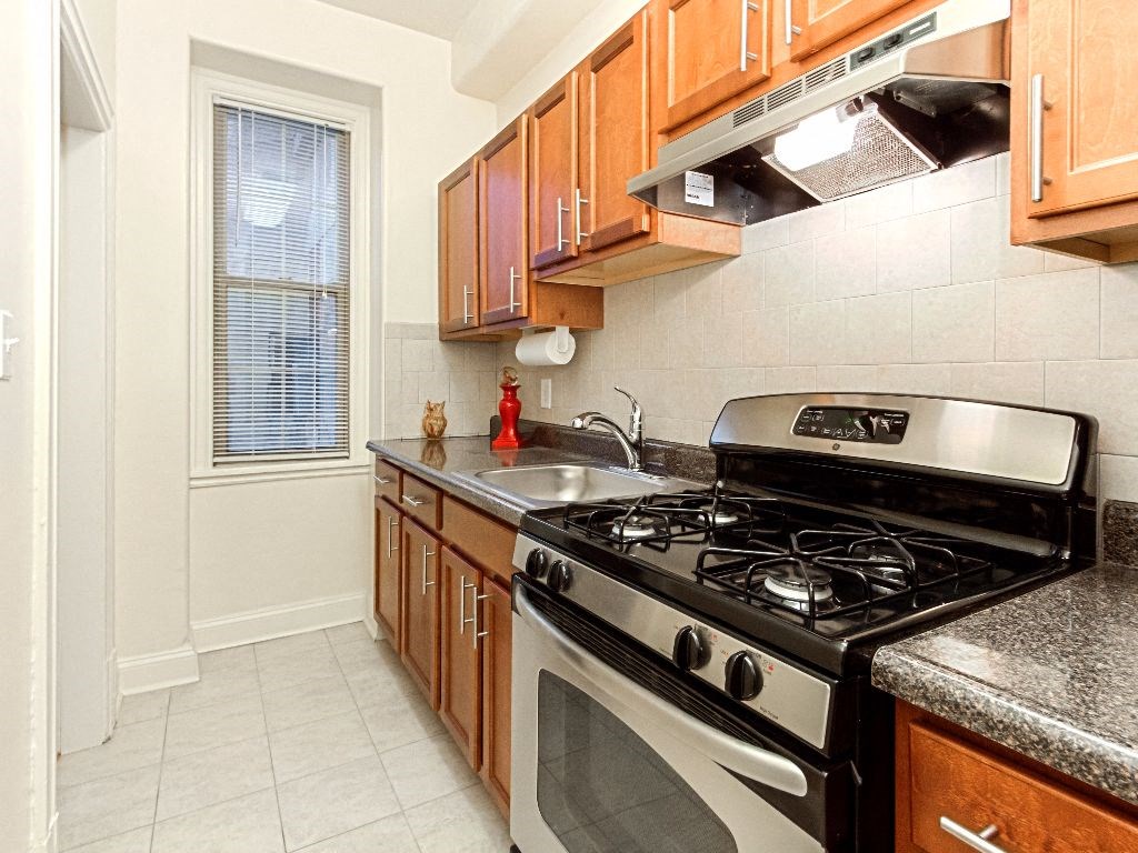 a kitchen with a stove top oven next to a window at the calverton apartments in washington dc