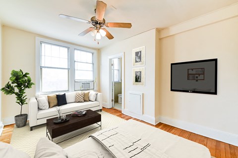 a living room with a white couch and a ceiling fan