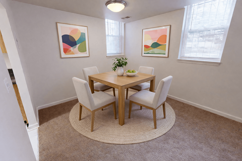 A dining room with a round table and chairs.