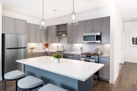A modern kitchen with a large island and stainless steel appliances.