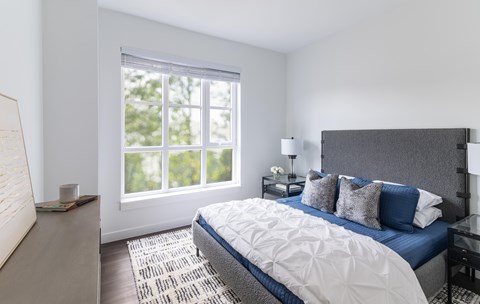 A bedroom with a large bed and a window.