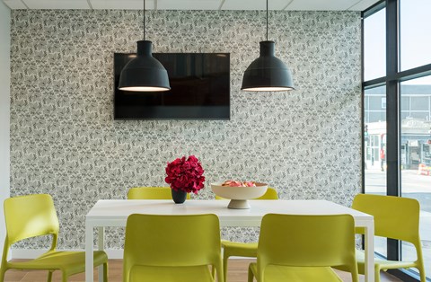 A dining room with a white table and yellow chairs.