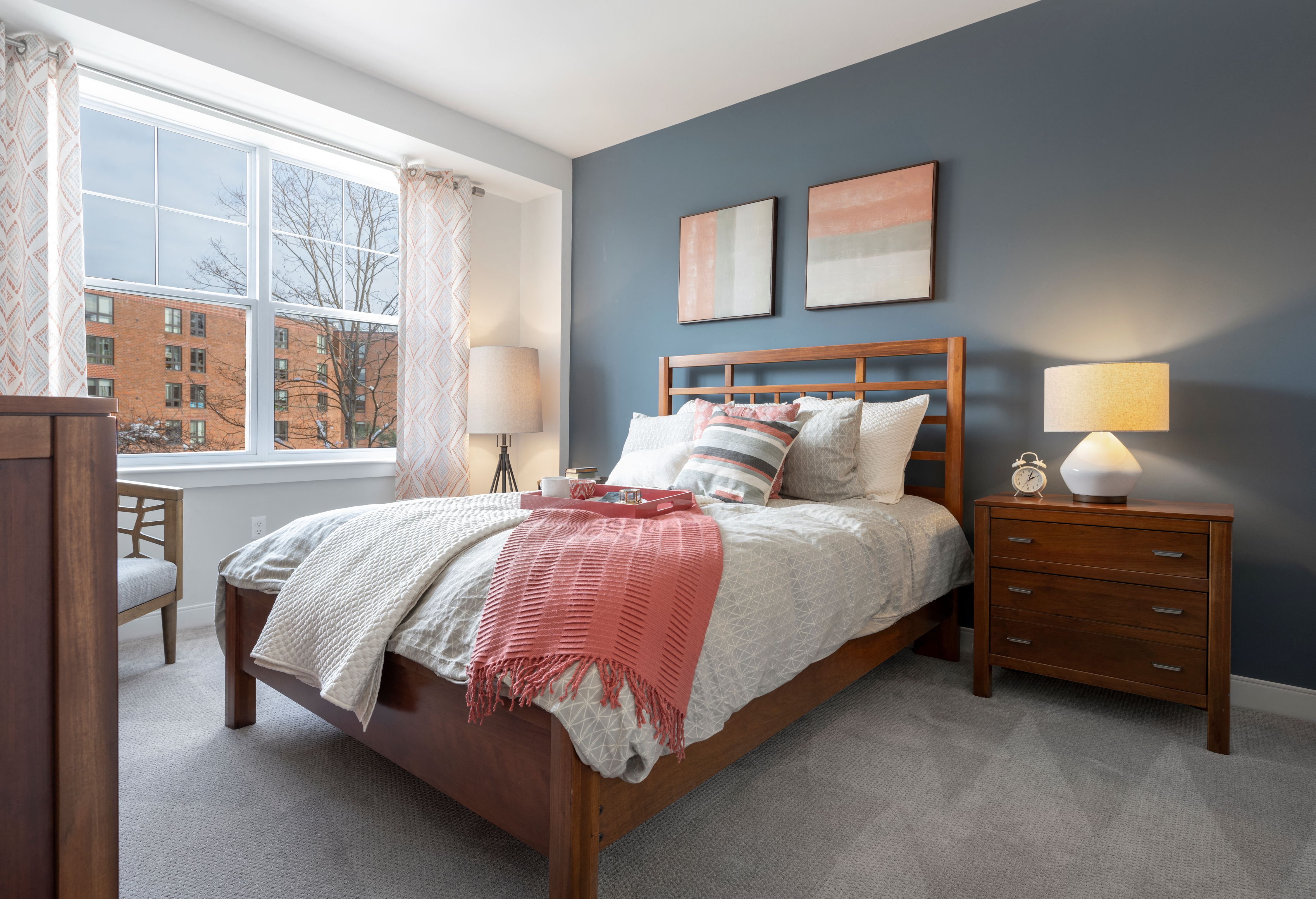 A bedroom with a bed, nightstand, and chair.