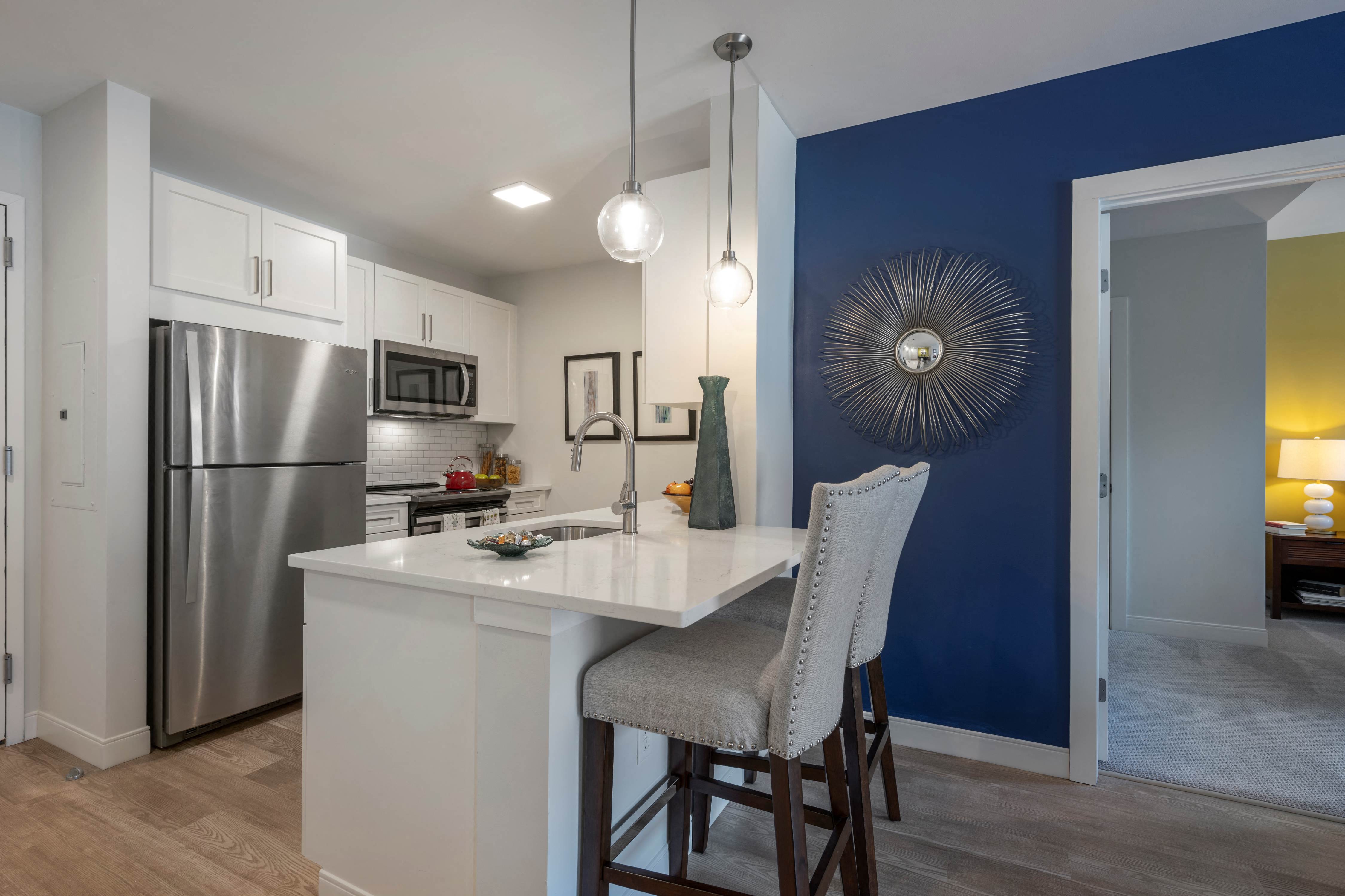 A kitchen with a white island and a blue wall.