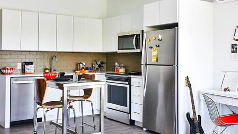 A kitchen with a refrigerator, microwave, and oven.