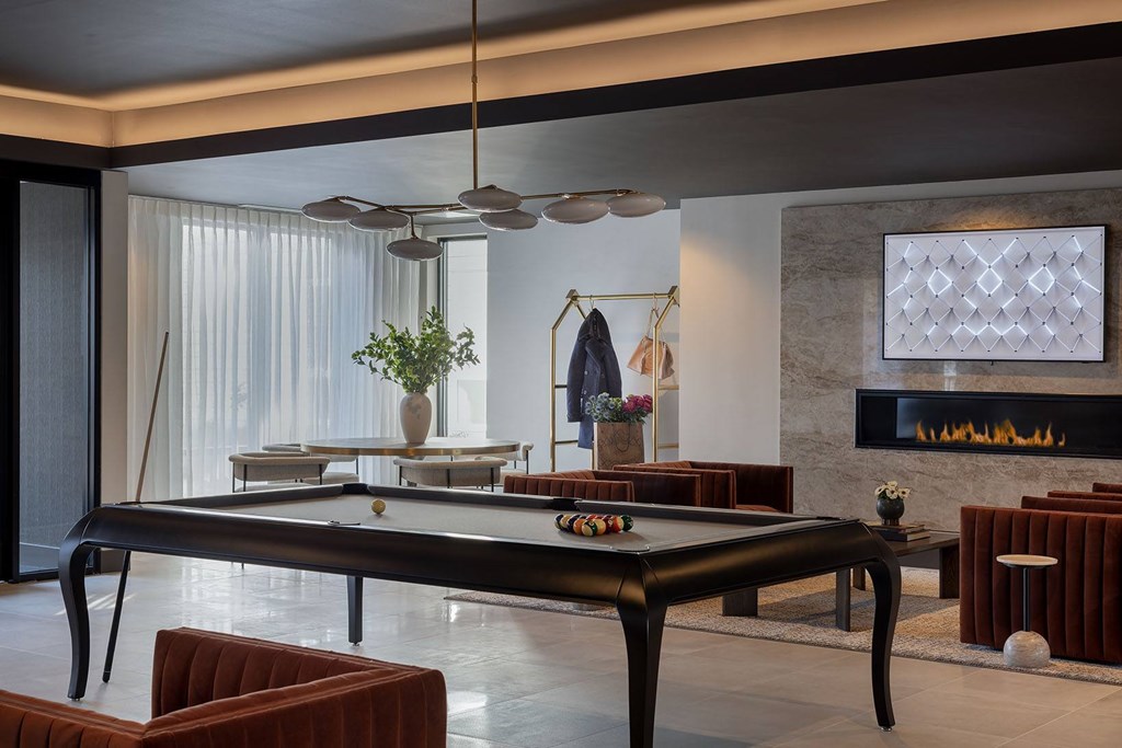A black pool table in a room with a fireplace.