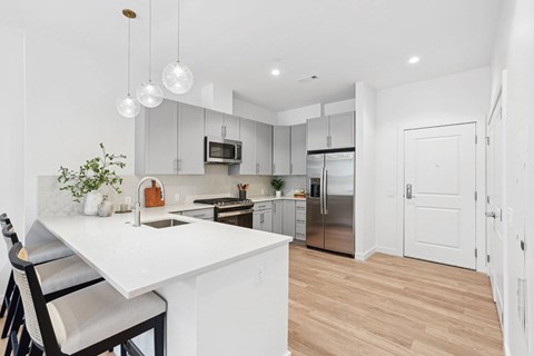 A kitchen with a white counter top and a refrigerator.