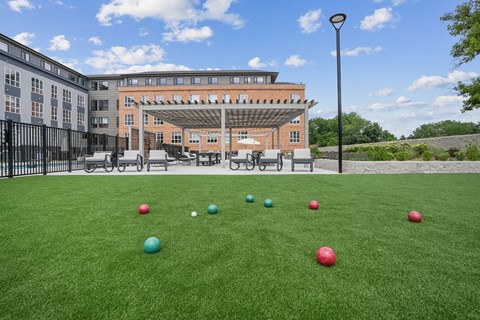 A lawn with several small balls on it in front of a building.