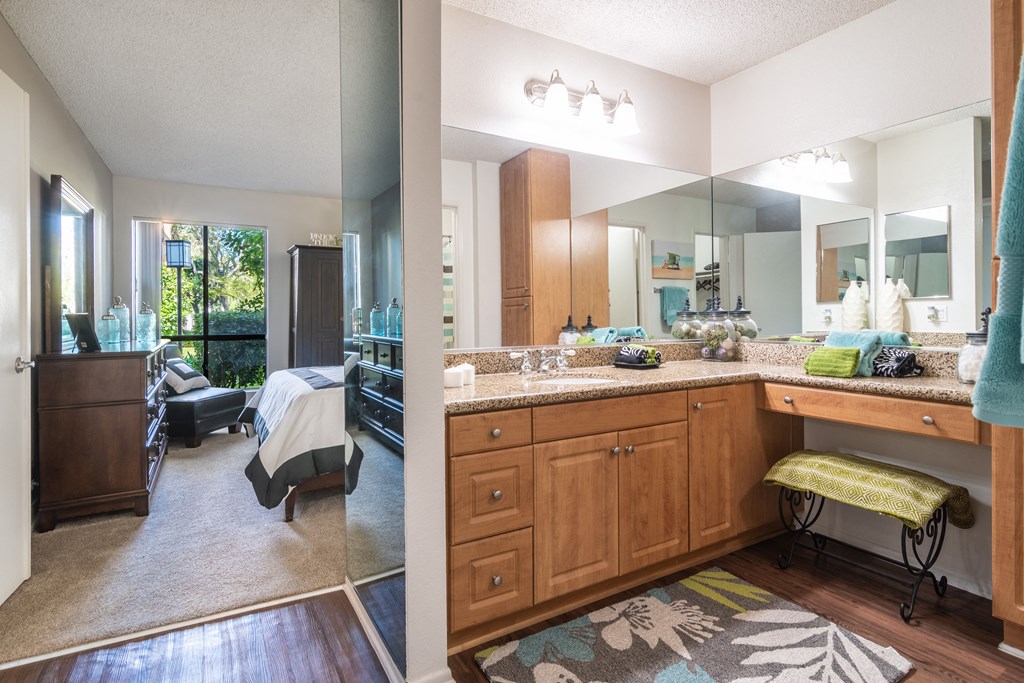 two views of a bathroom and a living room with a sink and a mirror