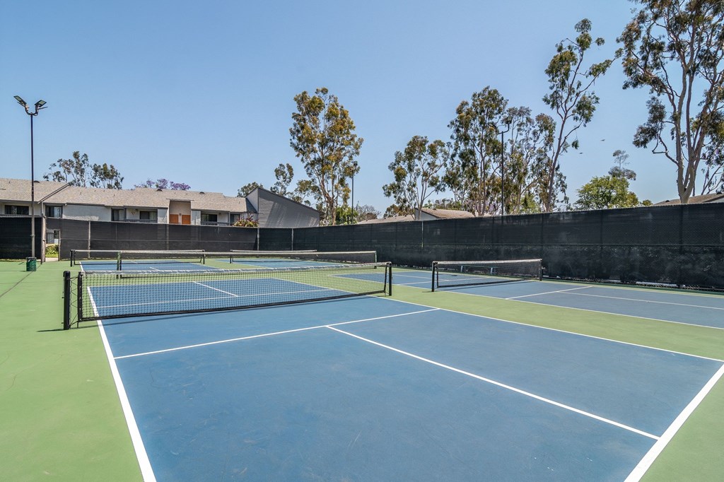 two tennis courts at the whispering winds apartments in pearland