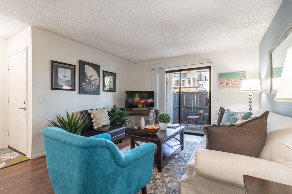 a living room with a sliding glass door to a balcony
