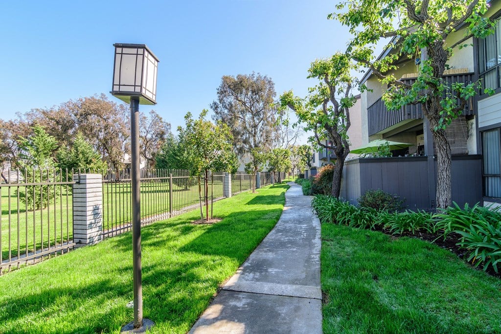 A residential area with a green lawn and a lamp post.