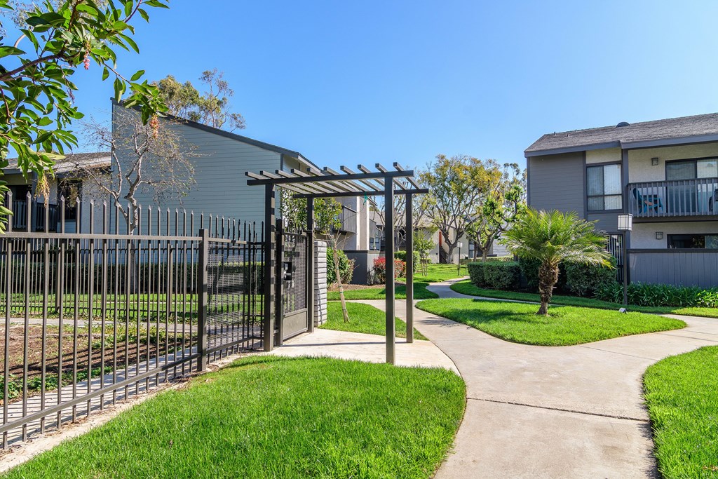 A black gate leads to a walkway in front of a building.