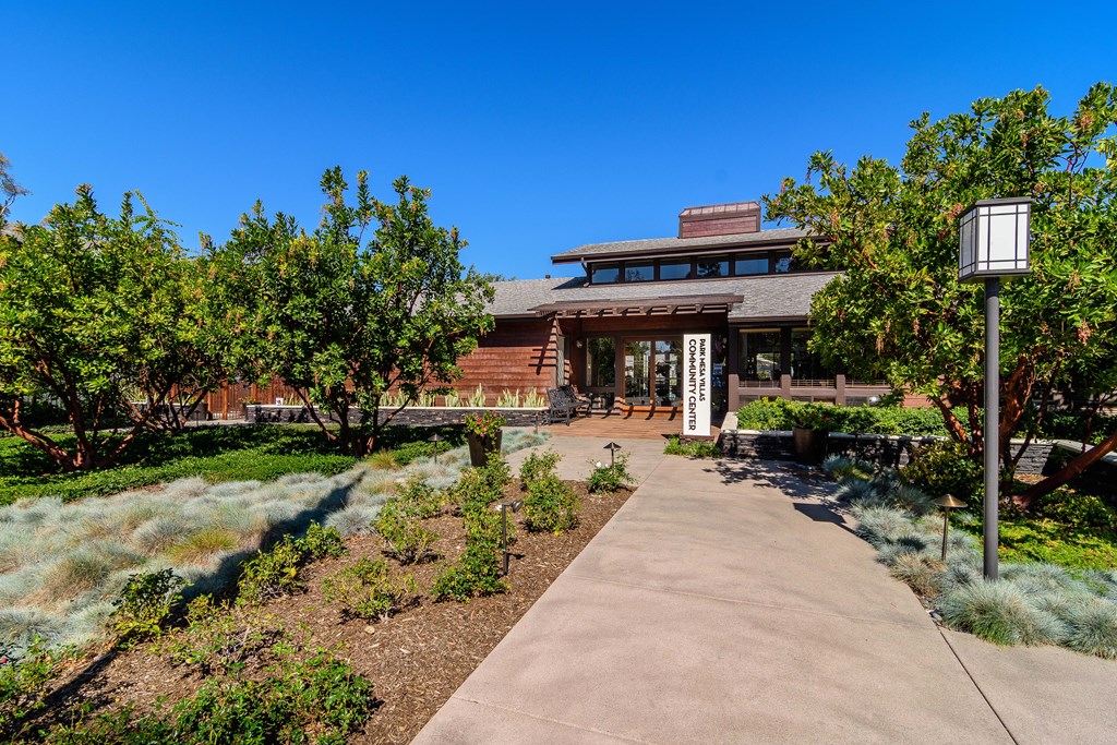 A building with a brown roof and a white sign in front of it.