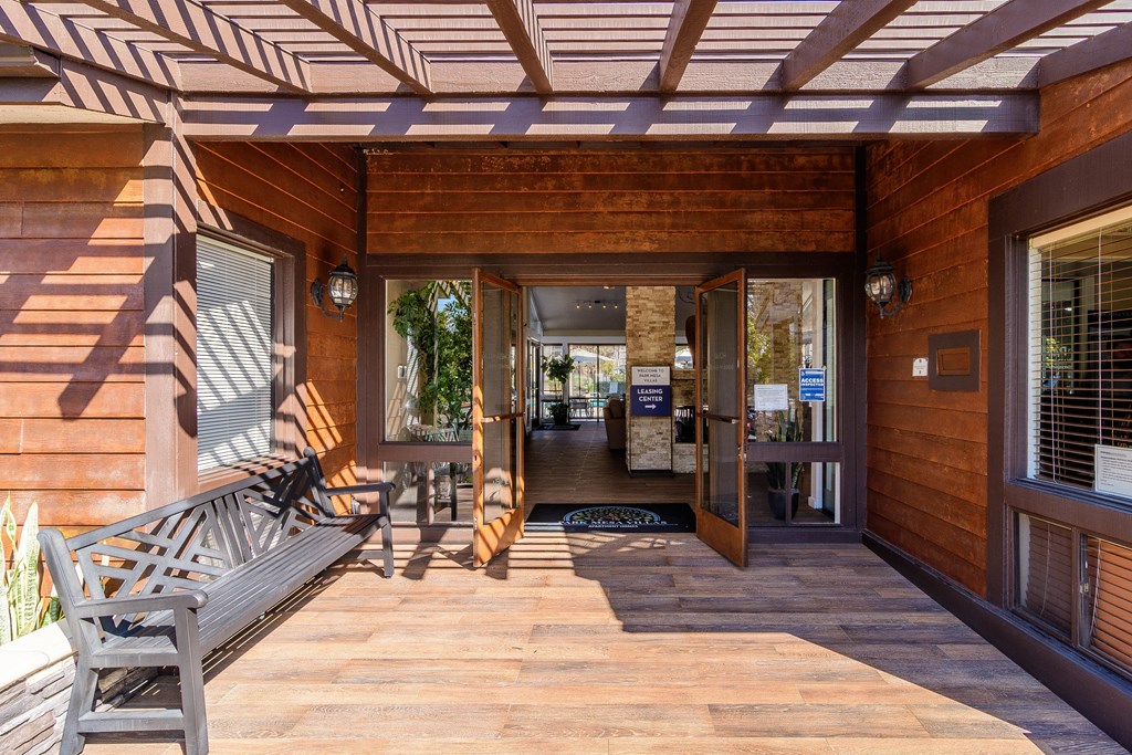 A wooden deck with a bench and a table.