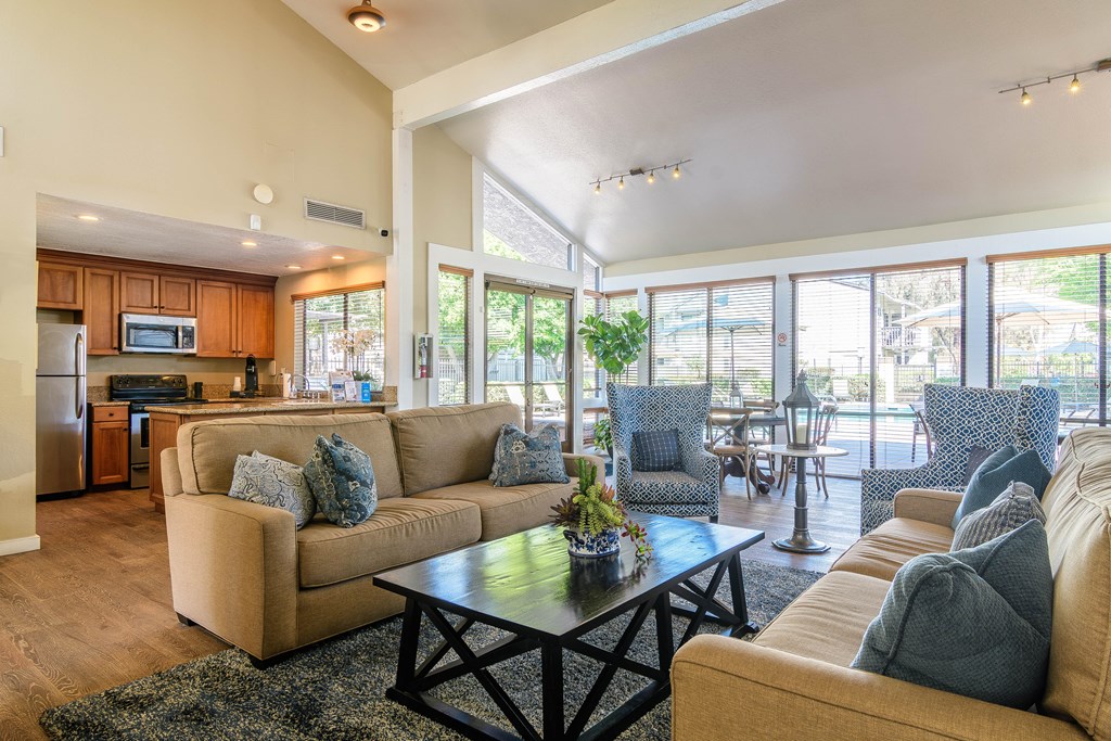 A living room with a beige couch and a black coffee table.