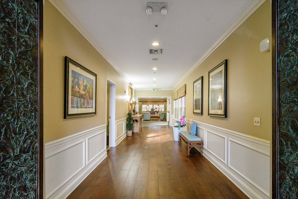 A hallway with a bench and pictures on the wall.