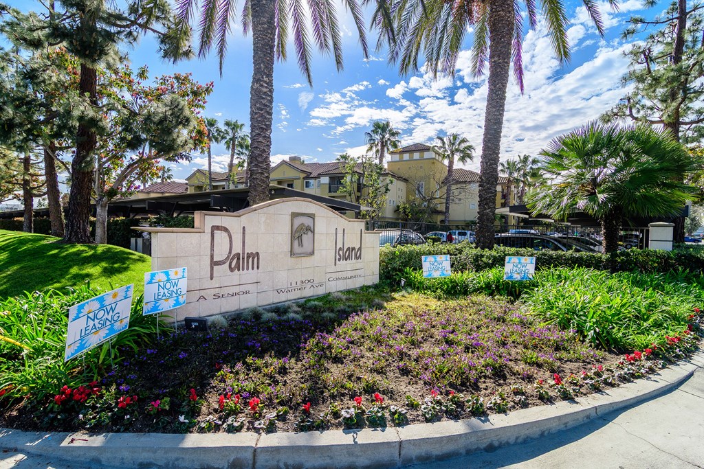 A sign that says Palm Island in front of some trees.
