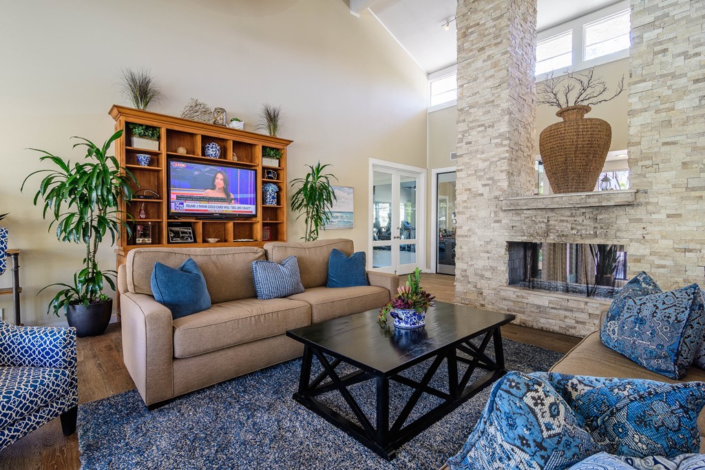A living room with a tan couch and a black coffee table.