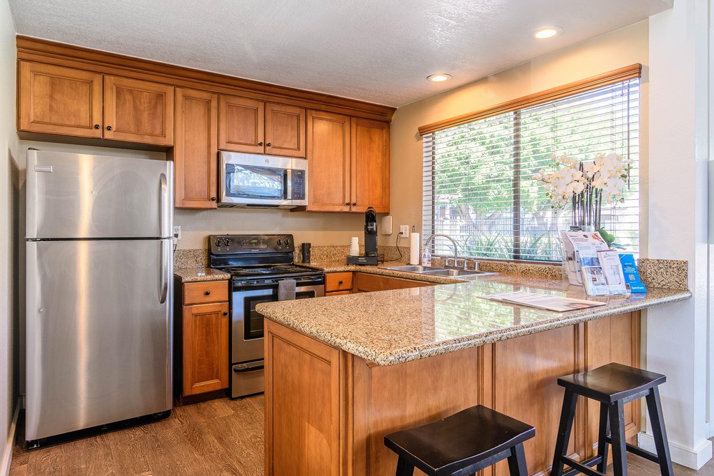 A kitchen with wooden cabinets and a granite countertop.