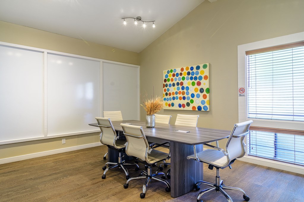 A conference room with a large table and chairs.