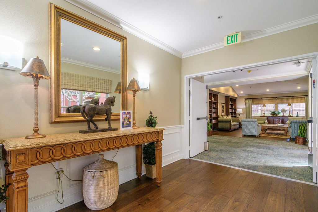 A room with a large mirror and a lamp on a console table.