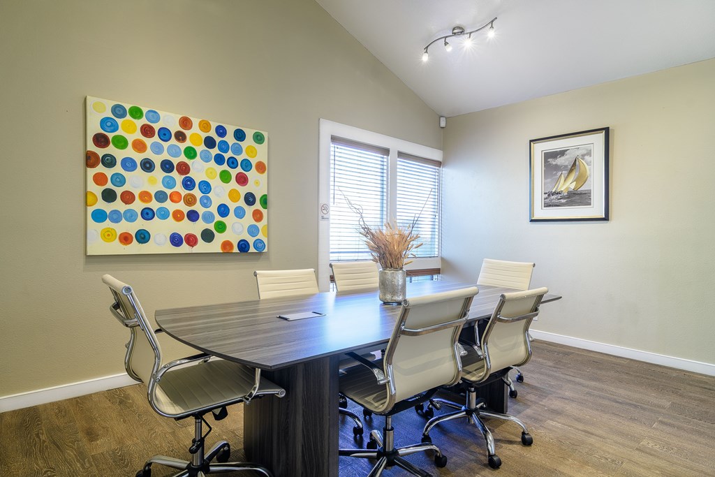 A conference room with a large table and chairs.