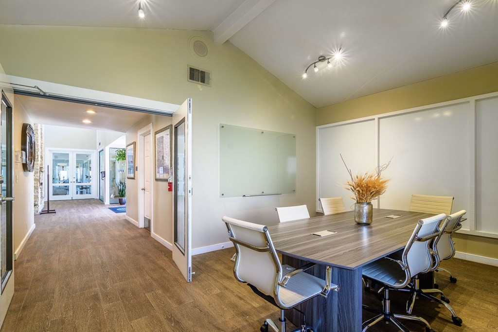 A conference room with a table and chairs.