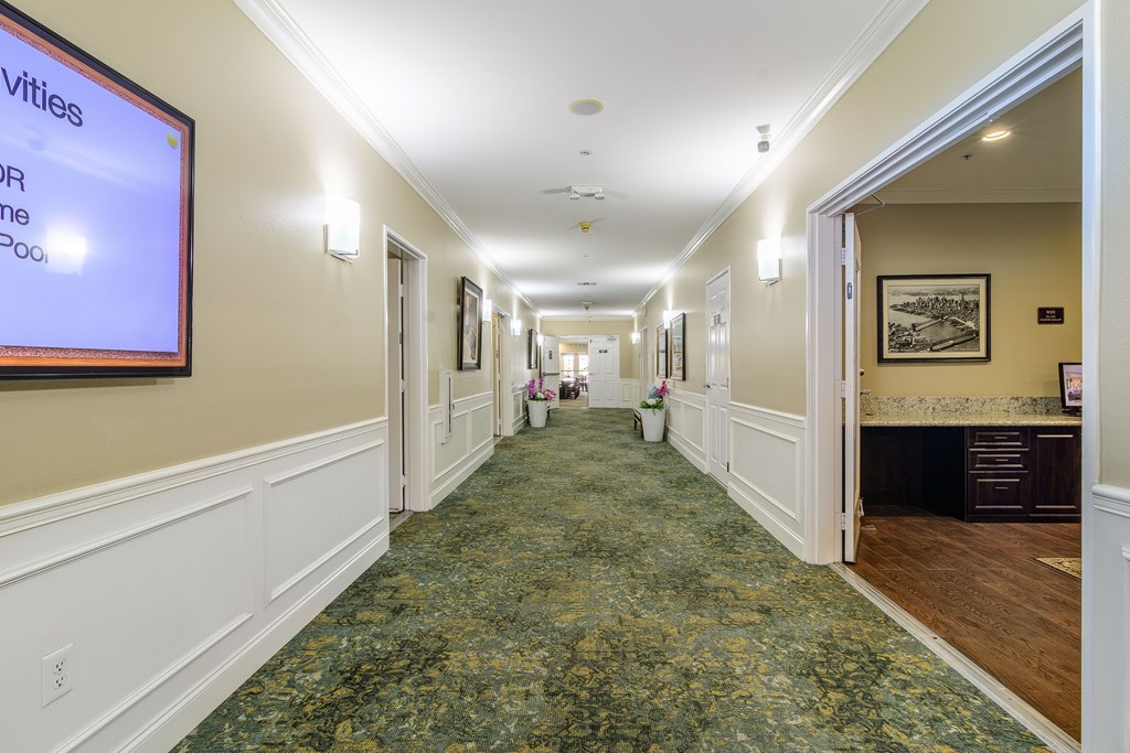A long hallway with a carpeted floor and white walls.