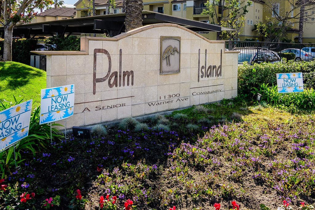 A sign for Palm Island with a senior apartment complex.