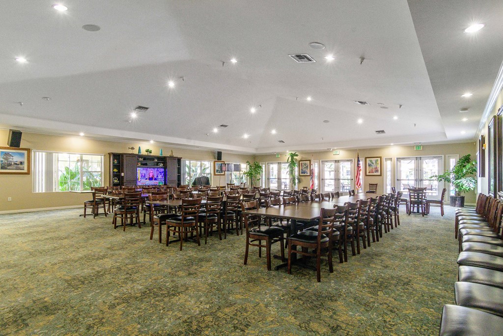 A large room with a carpeted floor and a long table with chairs.