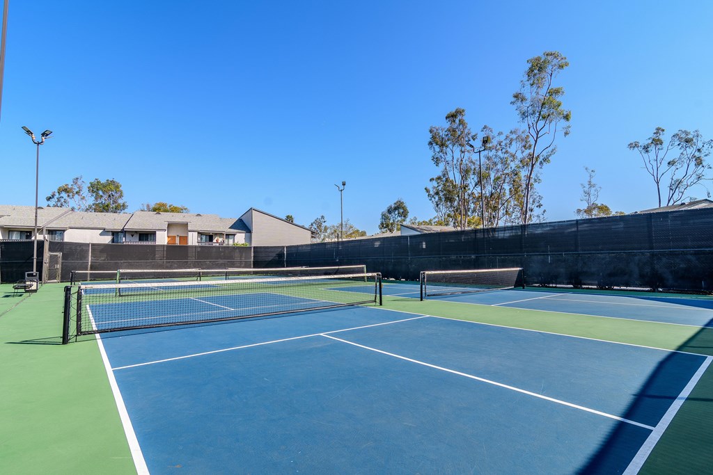 A tennis court with a net and two posts.