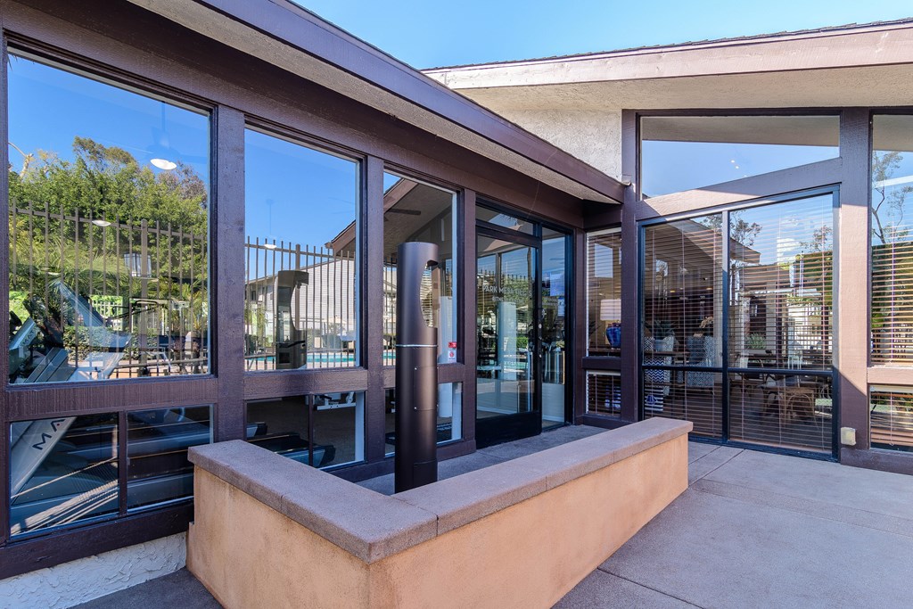 A modern building with a glass door and a brown railing.