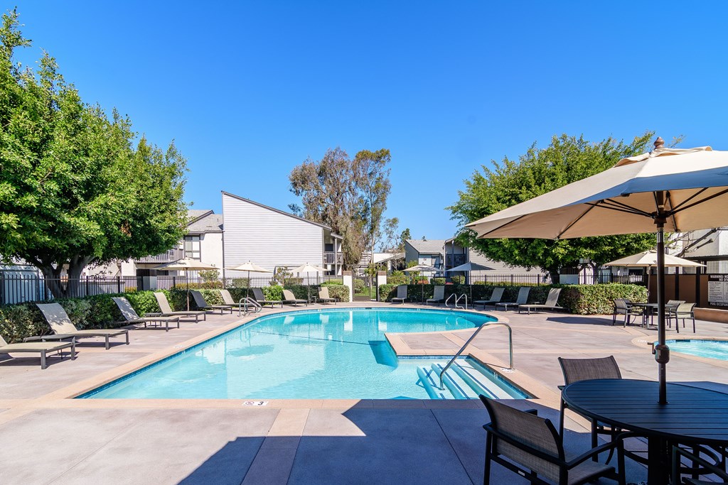 A pool surrounded by chairs and umbrellas.