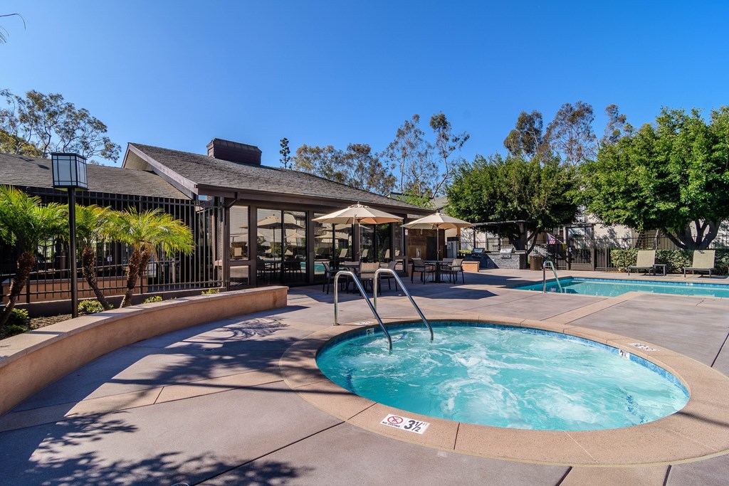A large outdoor swimming pool with a fountain in the middle.