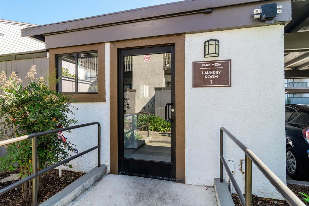 A brown and white building with a sign that says "Parking Hesa Laundry Room".