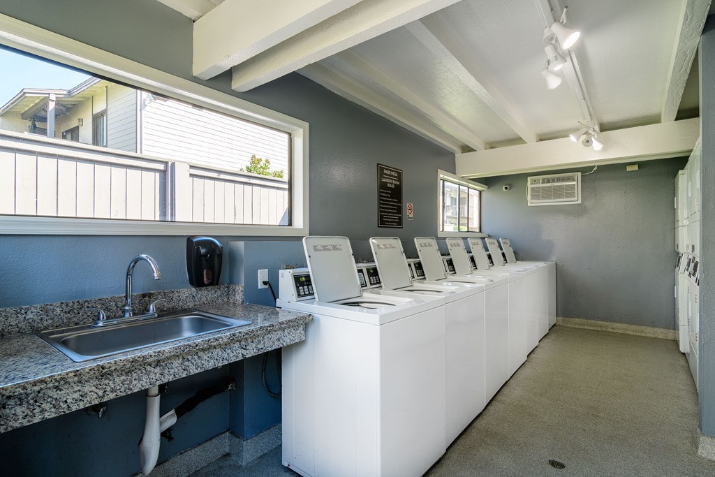 A public restroom with a row of sinks and mirrors.