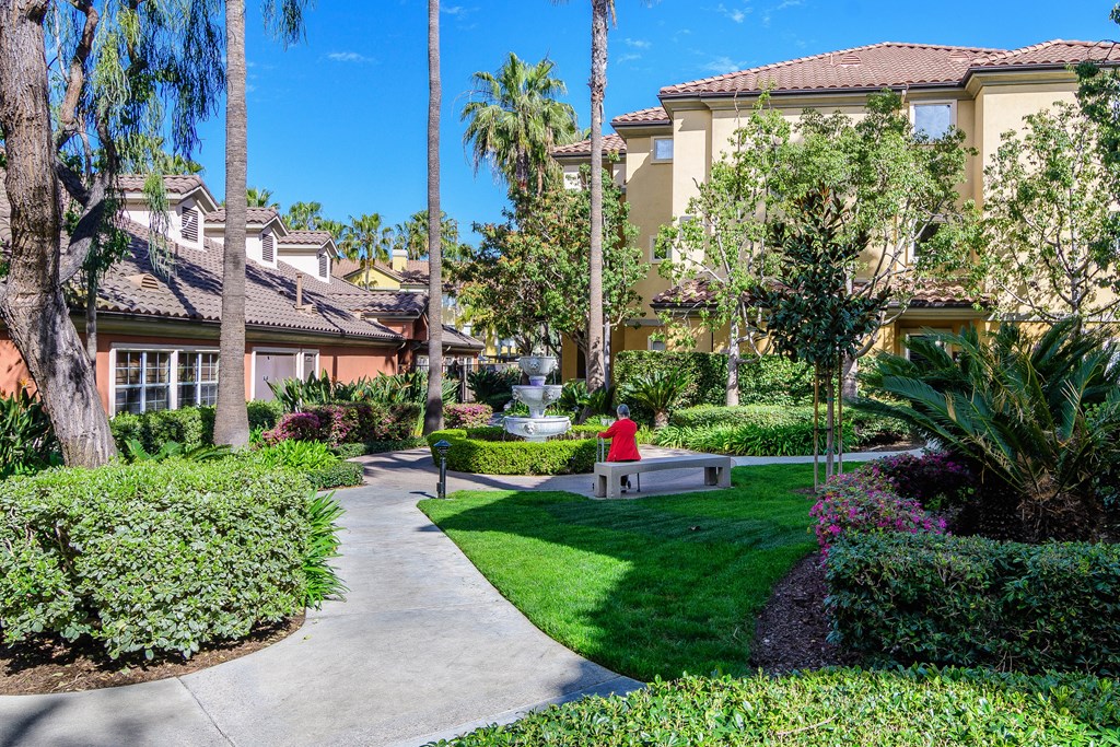 A residential area with a person in a red top walking on a path.