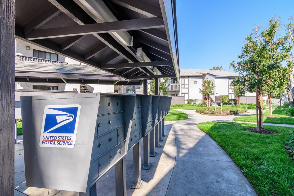 A United States Postal Service mailbox is on a metal pole.