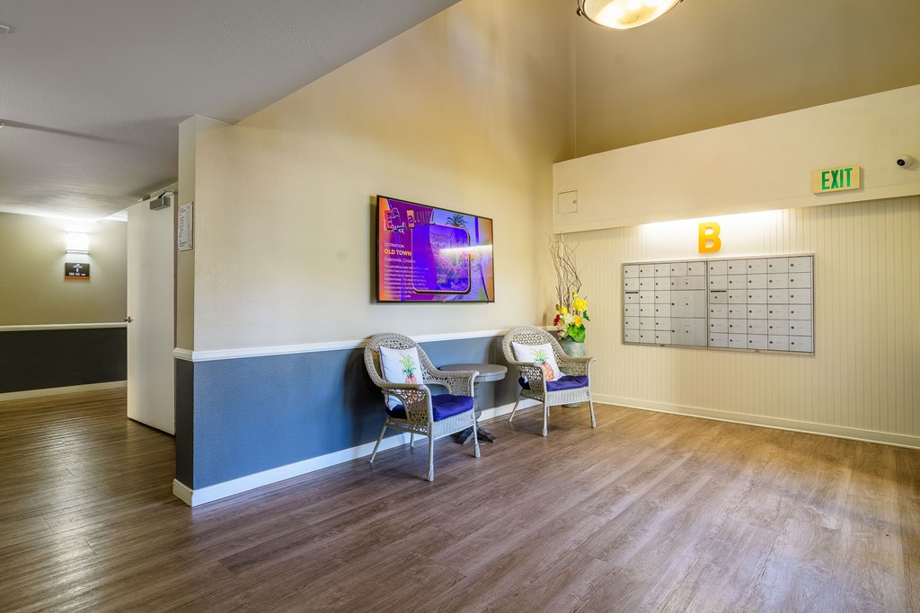 A waiting room with chairs and a TV on the wall.