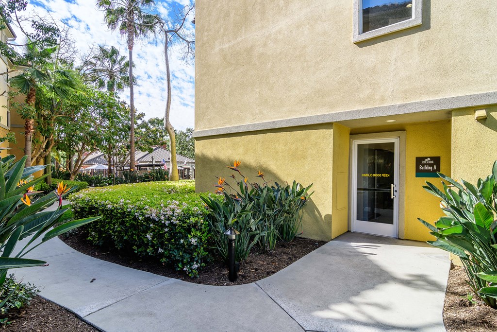 A yellow building with a glass door and a small window above it.