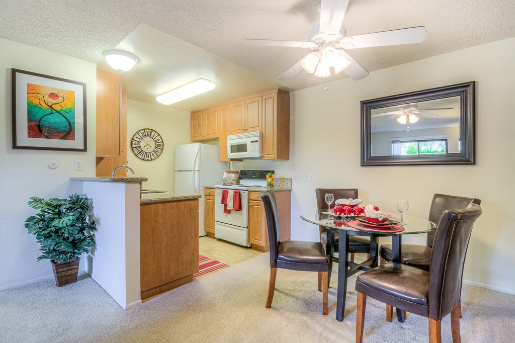 A kitchen with a dining table and chairs.