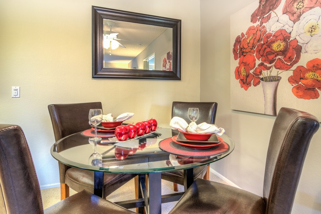 A dining table with chairs and a painting on the wall.