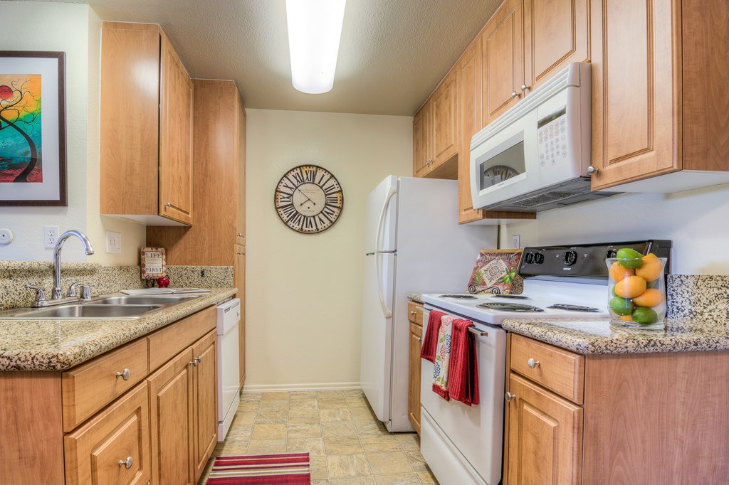 A kitchen with wooden cabinets and a white refrigerator.
